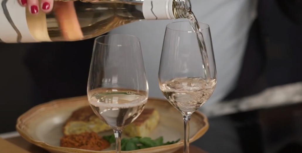 pouring Pinot Gris with dish